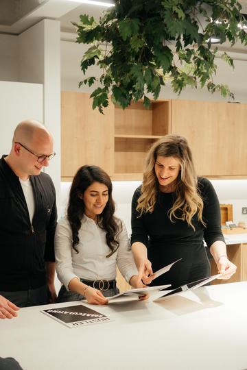 The Jack Fertility team stood around a table together looking at documents